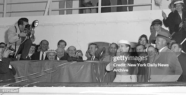 Her smiling mom and dad beside her, and surrounded by friends and well-wishers, Grace Kelly calls to friends on Pier 84 as the Constitution gets...