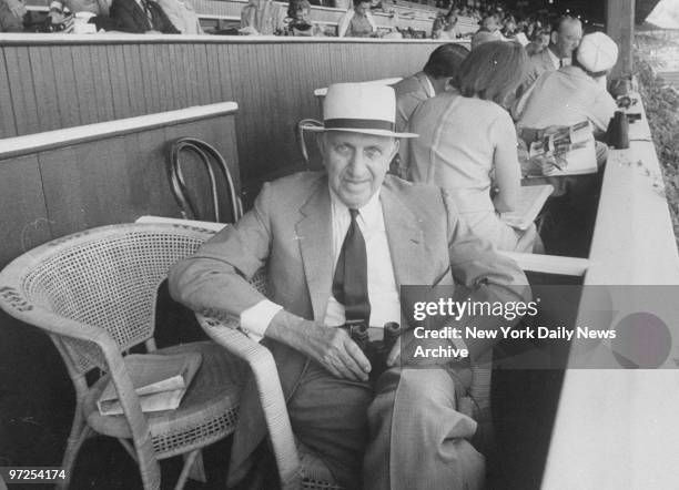 Harry Guggenheim gets ready to watch race on opening day at Saratoga, New York.