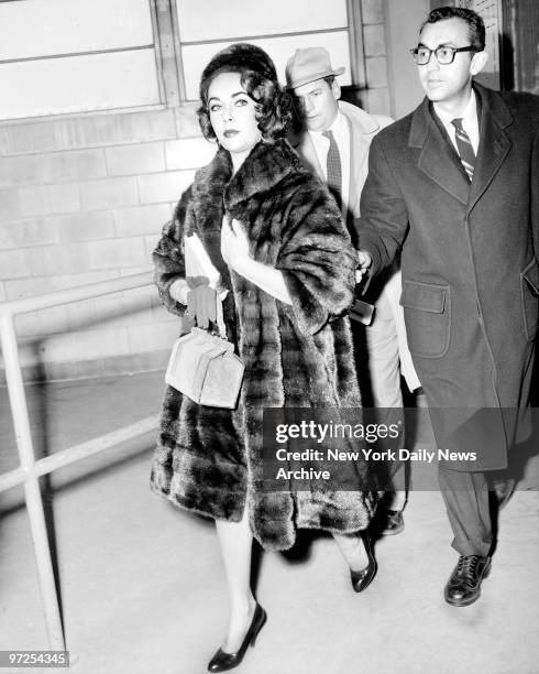 Elizabeth Taylor arrives at Newark Airport with personal physican Dr. Rexford Kennamer. Liz is here as a stone was dedicated at the grave of her...