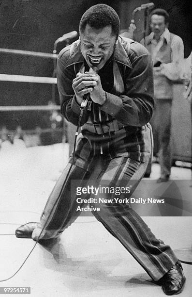 Heavyweight champ Joe Frazier sings in the boxing ring.
