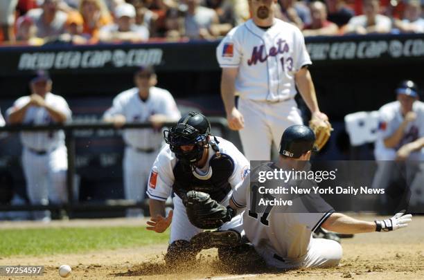 Ball bounces off the chest protector of New York Mets' catcher Jason Phillips as New York Yankees' catcher John Flaherty scores on a double by Miguel...