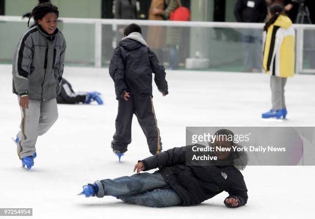 Elyas Sow a student at Public School 51, takes a spill on the ice during the grand opening of Manhattan's newest skating rink, The Pond, at Bryant...