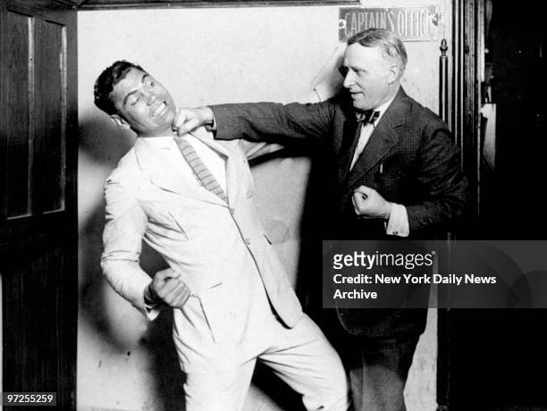 Heavyweight champion Jack Dempsey gets poked under the jaw by Chief of Detectives Michael Hughes.