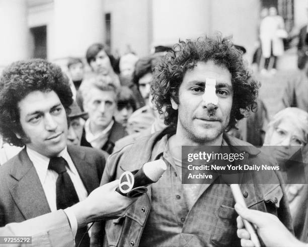 Bandage adorns the nose of Yippie Abbie HOffman as he leaves Federal Court and talks with the press. Abbie says his nose was hurt in fracas with cop...