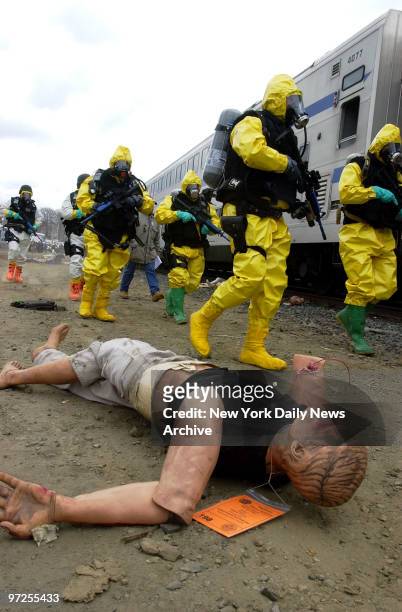 Emergency Service Unit police dressed in hazmat suits stand over a mannequin representing a casualty during a disaster drill named Operation Trifecta...