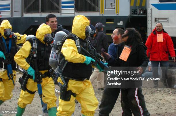 Emergency Service Unit police in hazmat suits have their rifles at the ready as they encounter simulated casualties during a disaster drill named...