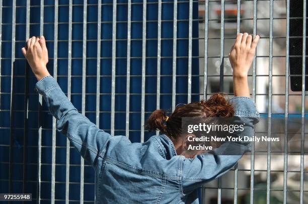 Emotional woman clings to fence on the perimeter of Ground Zero during ceremonies commemorating the third anniversary of the Sept. 11 terrorist...
