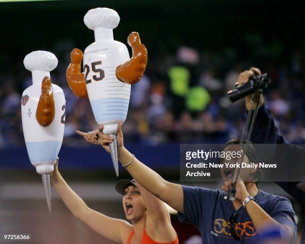 Fans at Shea Stadium hold inflatable hypodermic needles, with San Francisco Giants' Barry Bonds' uniform number on them, as they taunt the Giants'...