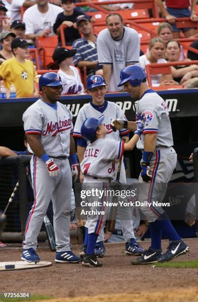 Batboy Garrett Zeile, the son of Montreal Expos' Todd Zeile, congratulates his dad after Zeile hit a go-ahead solo homer to left center field in the...