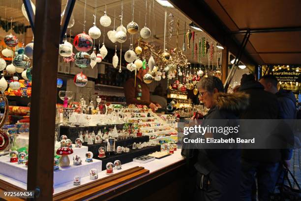 woman buying christmas decorations at lubeck christmas market - north sea market stock pictures, royalty-free photos & images