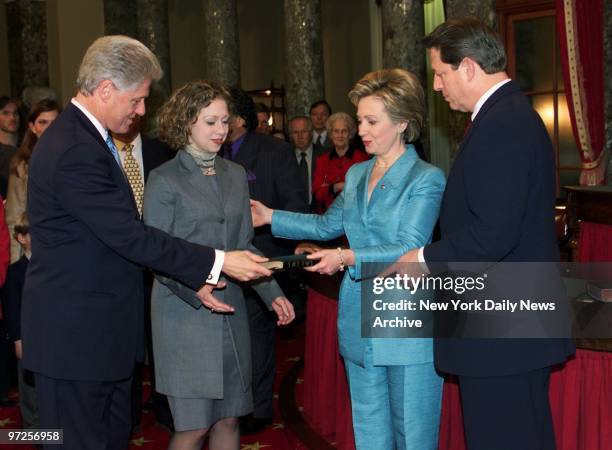 Hillary Rodham Clinton and President Bill Clinton hold bible as daughter Chelsea and Vice President Al Gore look on at re-creation of the swearing-in...