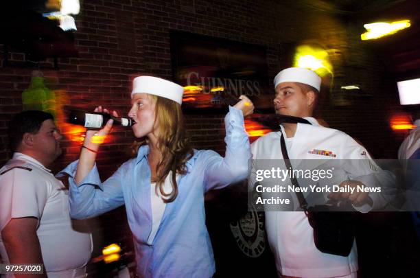 Beer-swigging woman wearing a borrowed sailor's cap uses sailor Jesus Martinez's neckerchief as a handle - or a leash - as she tugs him around the...