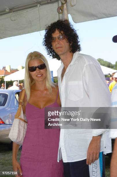 Howard Stern and girlfriend Beth Ostrosky grab a little shade under a tent during the annual Mercedes-Benz Polo Challenge at the Bridgehampton Polo...