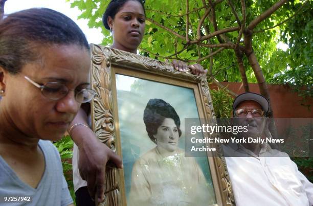 Benvenida Rocha holds a picture of aunt Gisela Coello with Coello's brother Julio Ricardo Coello and neighbor Mejaly Baro. Gisela Coello died in the...
