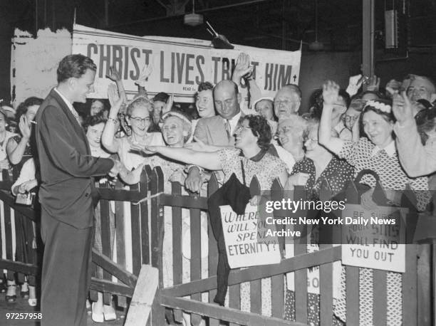 Evangelist Billy Graham greeted by crowd of followers upon arrival aboard the Queen Mary, after a five-month European tour, during which he held...