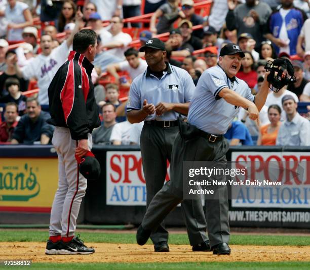 Home plate umpire Jerry Crawford throws Cincinnati Reds' Manager Dave Miley out of the game after he argued a call at first base in the fourth inning...