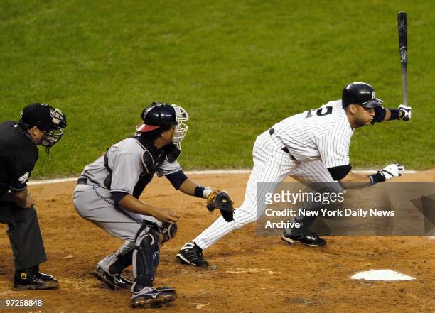 Home plate umpire Tim Tschida and Cleveland Indians' catcher Victor Martinez look on as New York Yankees' shortstop Derek Jeter hits a one-run double...