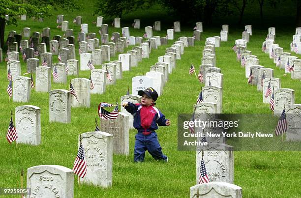 Christopher Gasper of Far Rockaway, Queens, is ready to place flag next to tombstone on Memorial Day at Cypress Hills Cemetery in Brooklyn.