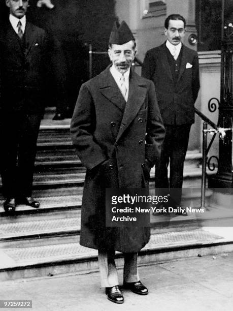 King Faisal of Iraq smiles for the camera while standing outside the Hyde Park Hotel in London.