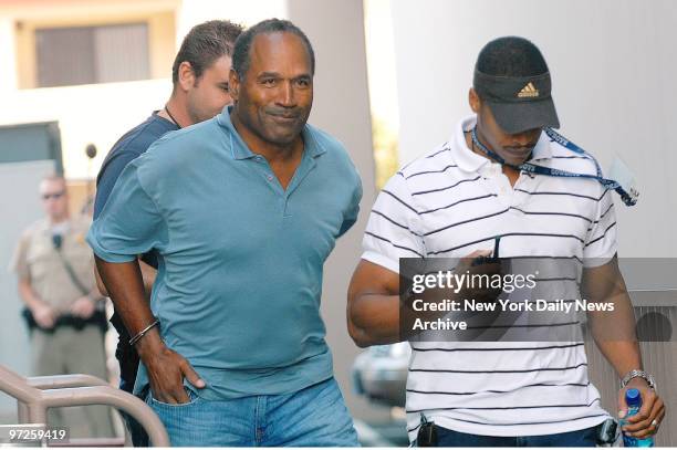 In handcuffs, O.J. Simpson is transferred by police officers to the Clark County Detention Center in Las Vegas, Nev., after being arrested in...