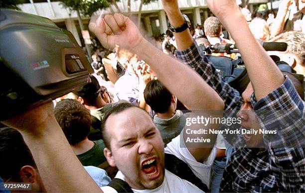 Fans and supporters of O.J. Simpson cheer outside the Los Angeles courthouse when the "not guilty" verdict was read after the criminal trial.,