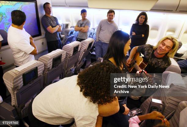 Cincinnati Reds' pitcher Bronson Arroyo entertains fellow passengers with his guitar as he and other Major League baseball stars take a flight to...