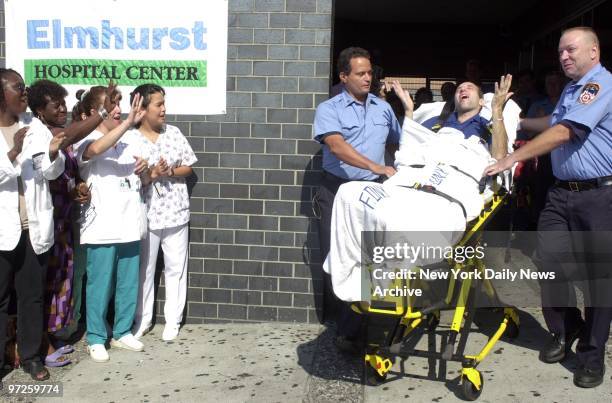 Hospital staff members wave goodbye to an elated Firefighter Joseph Vosilla as he is released from Elmhurst Hospital Center. Vosilla was critically...