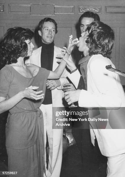 Bianca Jagger feeds cake to husband Mick Jagger as designer Halston looks on during Bianca's birthday bash at Studio 54.