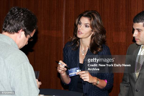 Cindy Crawford helps customers behind the counter at Le Parker Meridien hotel during a Visa Signature Card promotion.