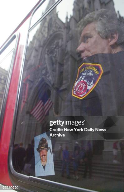 Firefighter looks pensively out the window of fire vehicle at St. Patrick's Cathedral on Fifth Ave. Long lines of firefighters from across the...