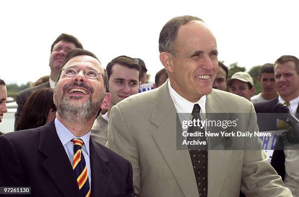 City Councilman Noach Dear looks skyward as a plane flying overhead interrupts his news conference with Mayor Rudy Giuliani at the North Channel...