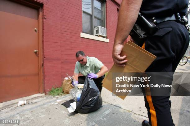 Hudson County Homicide Det. Tim Sullivan looks through garbage from the Park Ave. Hotel in Weehawken, N.J., where Jennifer Moore was last seen before...