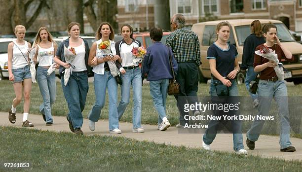 Mourners arrive with flowers at Columbine High School in Littleton, Colo., where two teenagers shot to death 12 students and a teacher before killing...