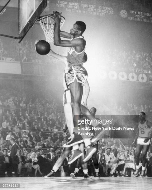 Bill Russell of the Boston Celtics goes rim high for a score against Harry Gallatin of New York in a game won by the Celtics against the Knicks at...