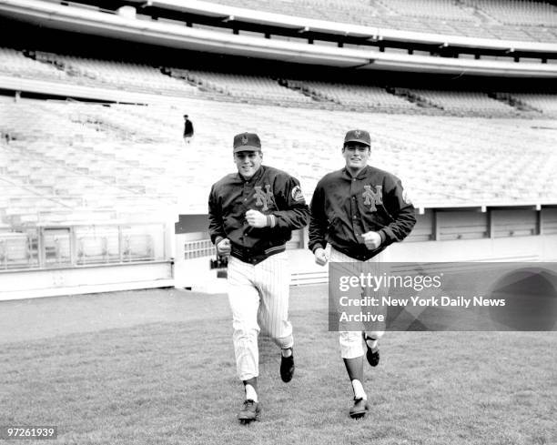 Rookie pitcher Tom Seaver and Bill Denehy of the Mets trot around Shea Stadium with their warmup jackets on during workout. Seaver is slated to start...