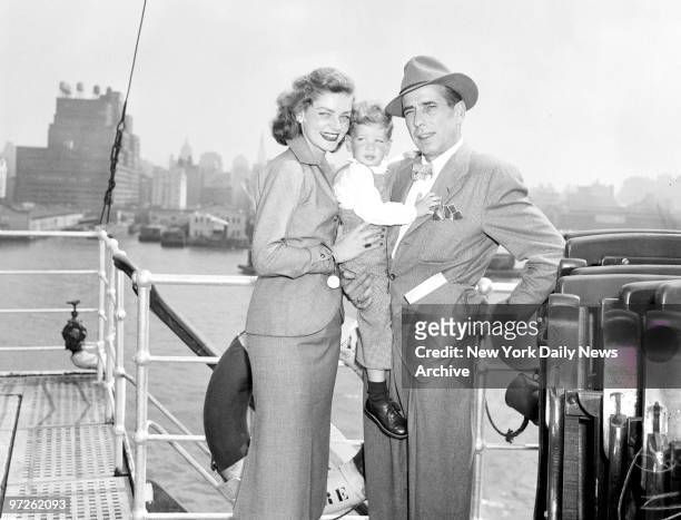 Humphrey Bogart, his wife, Lauren Bacall, and their son, Stephen, look very pleased on returning home aboard the Ile de France. Movie couple had been...