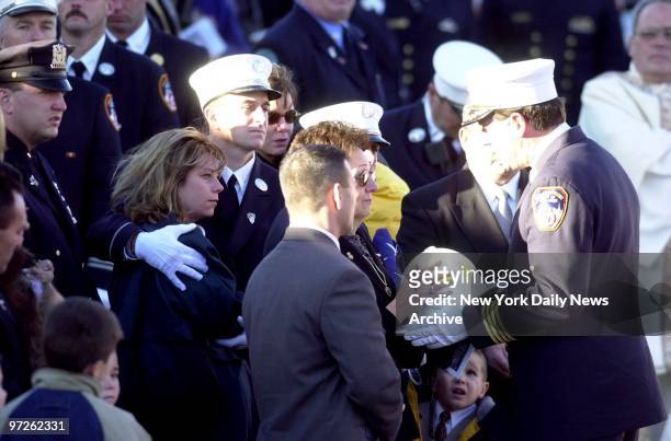Rosalie Downey is presented with firefighter helmet as family members look on during memorial service for her husband, Deputy Chief Raymond Downey,...