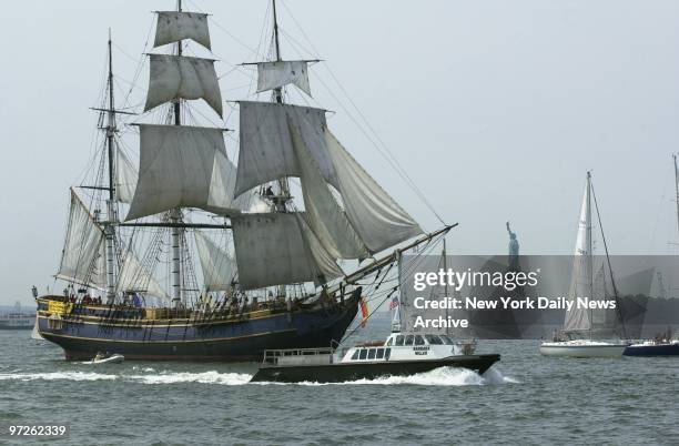 Hundreds of sailboats, motorboats and tall ships from around the country parade past the Statue of Liberty in New York Harbor this morning to...