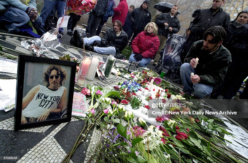 Fans of John Lennon light candles and leave flowers as they 
