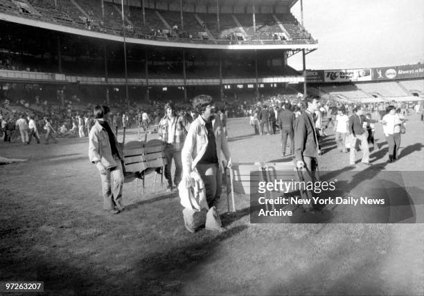 Fans walk off with seats on the last day of play at Yankee Stadium.