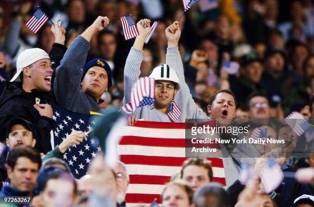 Fans wave their flags at a pregame tribute to victims and heroes of the terrorist attack on the World Trade Center before the game between the New...