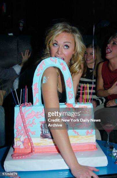Laura Bell Bundy, star of the Broadway musical "Legally Blonde," takes a bite out of her purse-shaped cake while celebrating her 26th birthday at the...