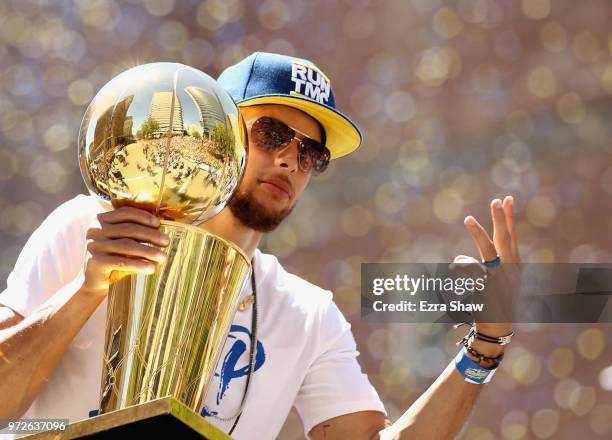 Stephen Curry of the Golden State Warriors holds the championship trophy during the Golden State Warriors Victory Parade on June 12, 2018 in Oakland,...