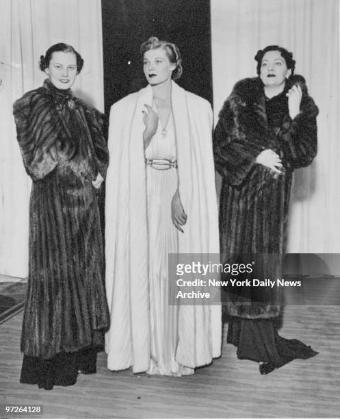 Fashions of the '30s: Evelyn Sheldon, in an evening cape of eastern mink; Betty Douglas, in a floor length cape of I. J. Fox Russian ermine, and Ruby...