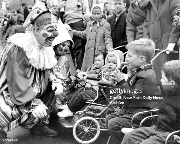 Clowns light up the faces of children watching Macy's Thanksgiving Day parade on Central Park West.