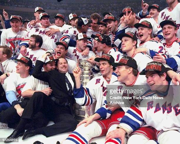 Coach Mike Keenan and New York Rangers surround the Stanley Cup on the ice at Madison Square Garden after the Rangers defeated the Vancouver Canucks...