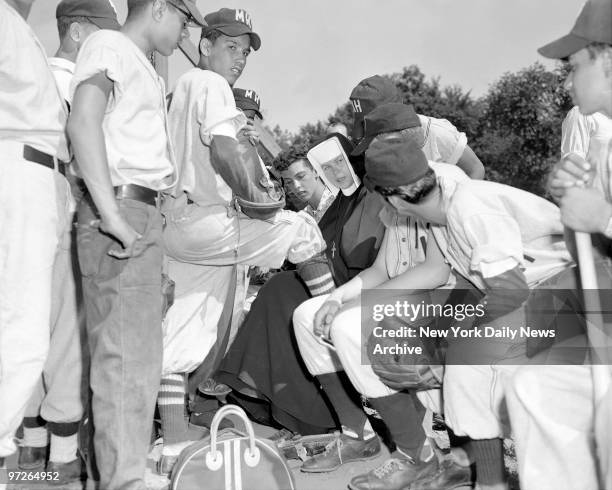 Coach Sister Mary Roberta gives last-minute pep talk to Madonna House nine just before her young stalwarts took the field at Central park to play in...