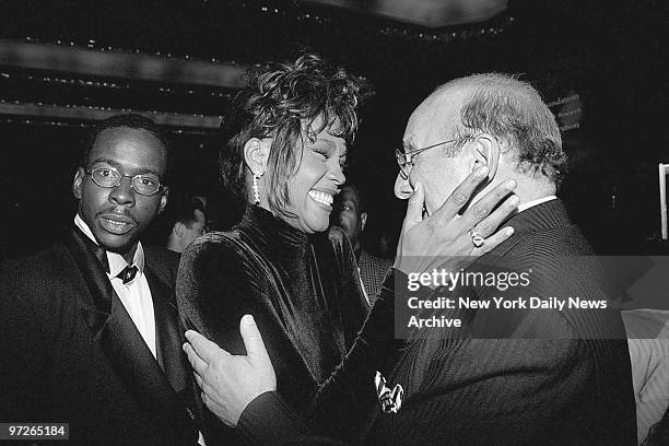 Bobby Brown looks on as his wife, Whitney Houston, congratulates Clive Davis, president of Arista Records, at a T.J. Martell benefit dinner for held...