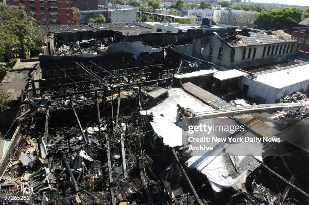 Officials examine the charred remains of the Paradise Mattress factory, in Bushwick, Brooklyn, burned out when a six-alarm blaze raged through it...