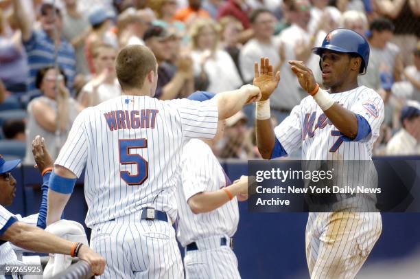 New York Mets' shortstop Jose Reyes is congratulated by third baseman David Wright after scoring on Carlos Beltran's two-run double to give the Mets...